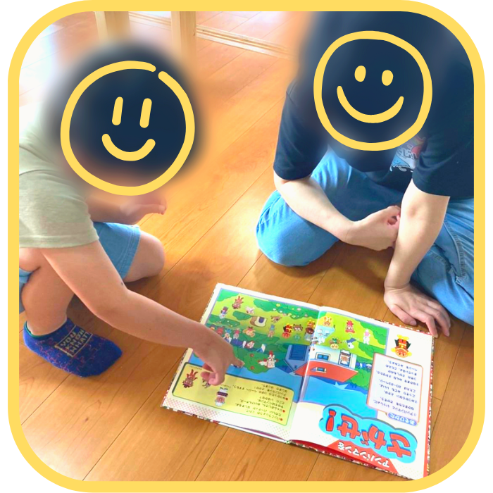 職員と絵本を読み、文字や言葉を学ぶ様子